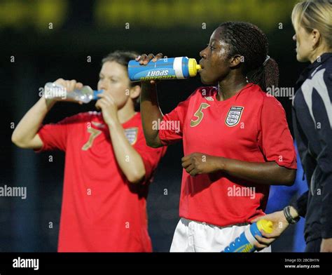 Karen Carney of England (left) and Anita Asante of England take on water during the match Stock ...