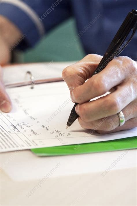 Nurse writing notes - Stock Image - C042/6461 - Science Photo Library