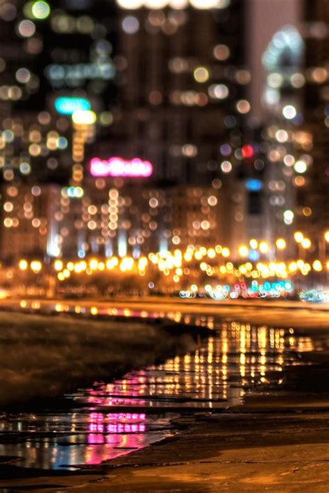 blurry city lights reflected in the water at night