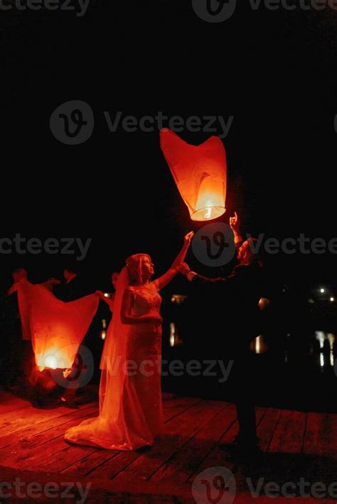 newly married couple embracing each other with the red Chinese sky ...