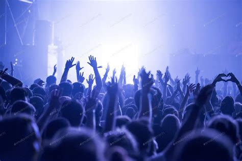 Crowd at a music concert, audience raising hands up