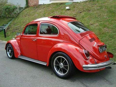 an old red car is parked on the street