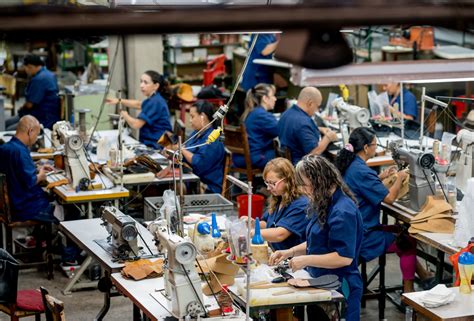 Group of Latin American manual workers working at a shoe-making factory ...