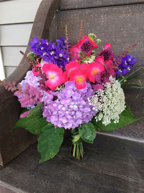 a bouquet of flowers sitting on top of a wooden bench