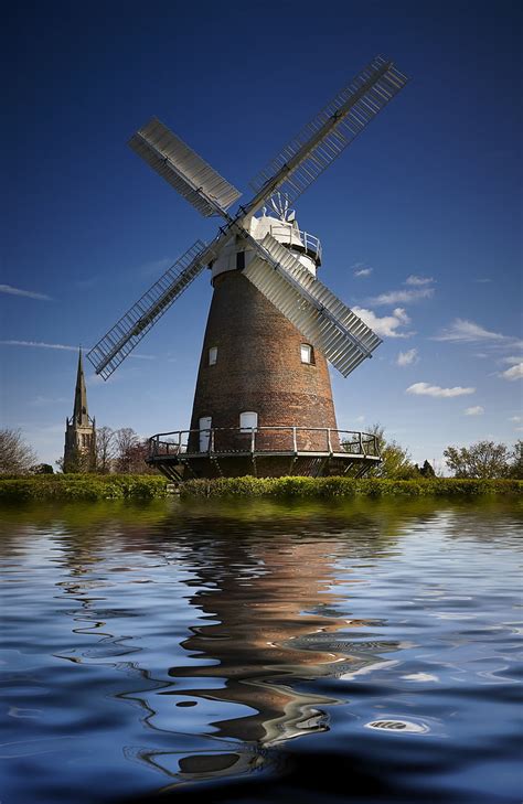 Royalty-Free photo: Brown windmill beside the body of water | PickPik