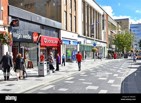 Shoppers high street retail shopping area in town centre Slough Berkshire UK paved-over road ...