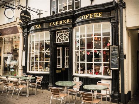 the outside of a coffee shop with tables and chairs