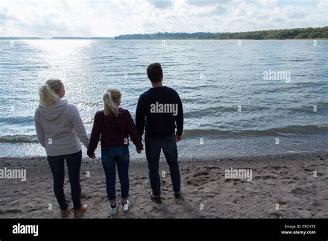 A family at the beach holding hands Stock Photo - Alamy