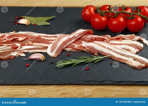 Raw Bacon Slices, Spice and Tomato on Black Board Stock Photo - Image ...