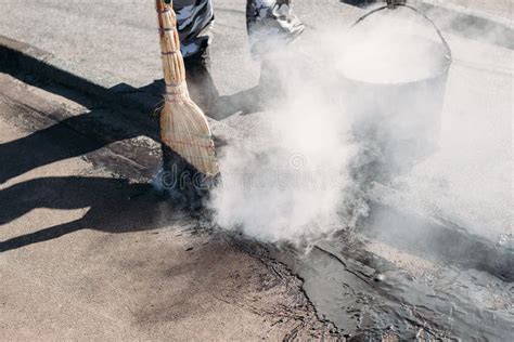 Worker Repairs the Roof with Molten Tar from a Bucket with a Broom ...