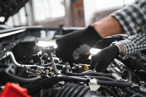 Premium Photo | Mechanic examining under hood of car at the repair garage