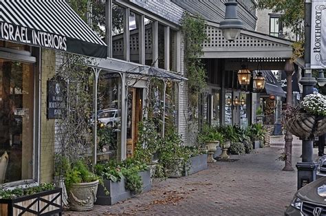 an alley way with many windows and plants growing on the side of each building in front of it