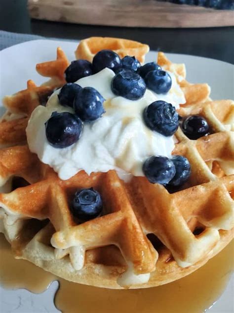 a waffle topped with blueberries and whipped cream