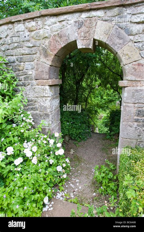 Stone archway in old garden wall with prominant keystone leading down Stock Photo: 24725971 - Alamy