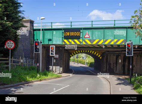 Low bridge warning sign on railway bridge in Cheshire UK Stock Photo - Alamy