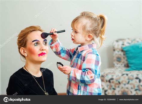 Download - Cute little girl are doing makeup for her a beautiful mother ...