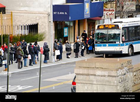 Commuters waiting at bus stop, MTA Q60 public transportation bus Stock ...