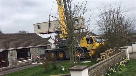 Crane Lifting a mobile home over a house - YouTube