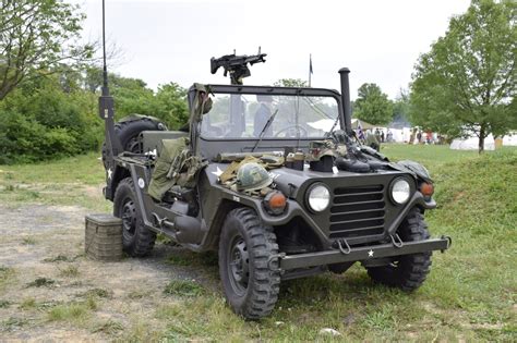 an army vehicle parked on the side of a dirt road