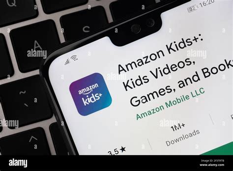 Amazon Kids+ app seen on the screen on smartphone which is placed on the laptop keyboard. Kids ...