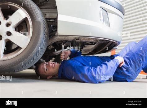 Auto mechanic under car Stock Photo - Alamy