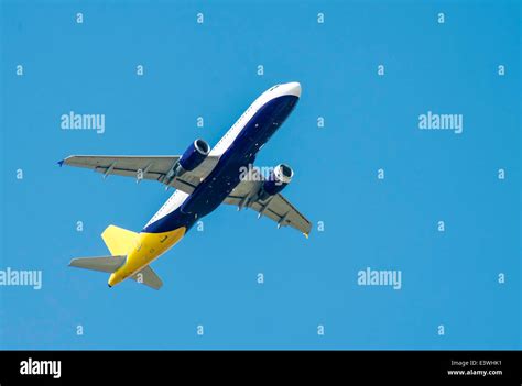 Flying white plane on blue sky background Stock Photo - Alamy