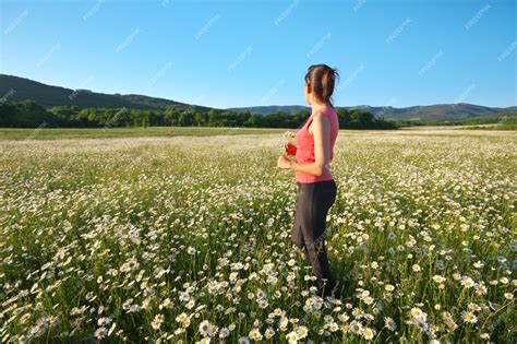 Premium Photo | Girl in daisy wheel spring flower field