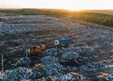 Garbage truck unloads rubbish in landfill. Landfill waste disposal. Garbage dump with waste ...