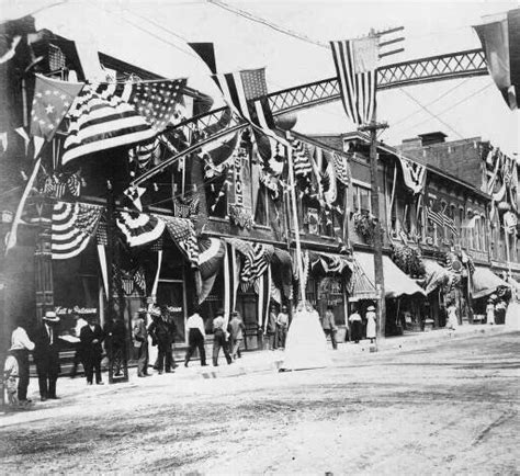 an old black and white photo of people standing in front of buildings ...