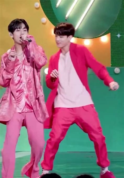 two young men in pink outfits on stage