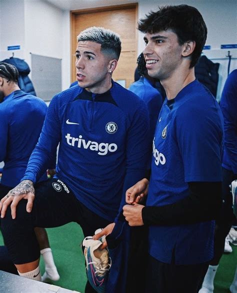 two men in blue soccer uniforms standing next to each other with their hands on their hips