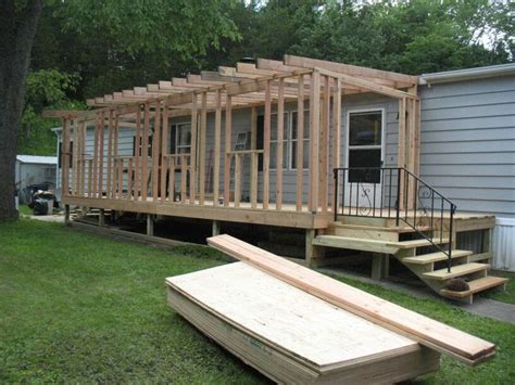 a house being built in the yard with wooden steps leading up to it's front door