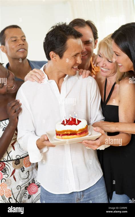 Friends surprising man with birthday cake Stock Photo - Alamy