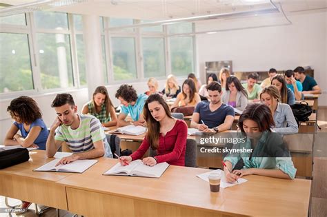 Large Group Of Students Sitting In Classroom And Learning High-Res ...