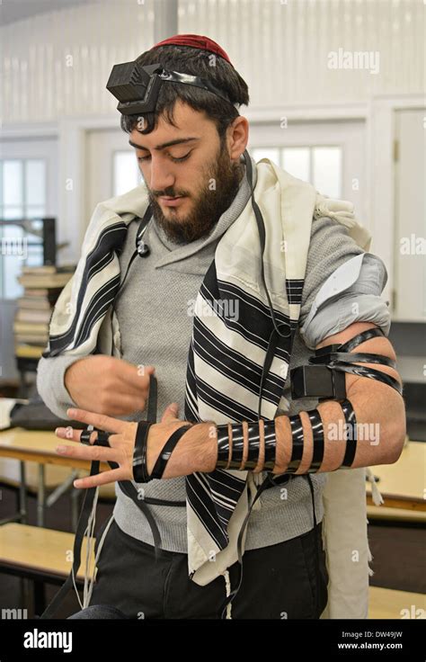 Religious Jewish young man putting on phylacteries - teffilin - at Stock Photo: 67092897 - Alamy