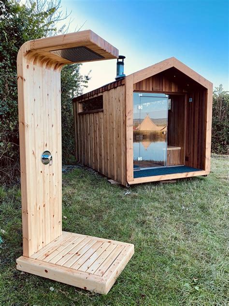 a wooden structure with a glass door in the grass