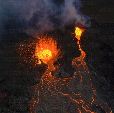 From above magma sparks out of the volcano hole and run like rivers of ...