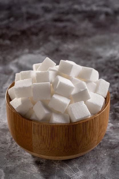 Premium Photo | White sugar cubes in wooden bowl