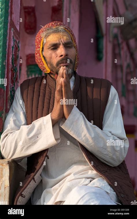 A Hindu Pujari (priest) prays at sunrise at Vishram Ghat, Mathura, Uttar Pradesh, India Stock ...