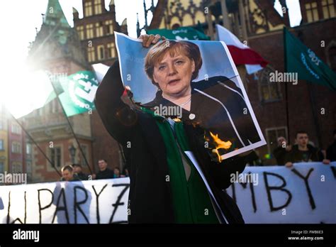 Protester burns picture of Angela Merkel during anti immigrant and anti ...