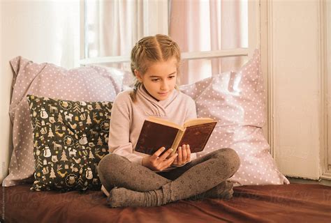 "Little Girl Reading A Book" by Stocksy Contributor "Aleksandra Jankovic" - Stocksy