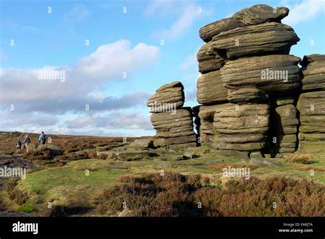 A group of walkers pass the Wheel Stones, Derwent Edge, Derwent Moor, Derbyshire, England, UK ...