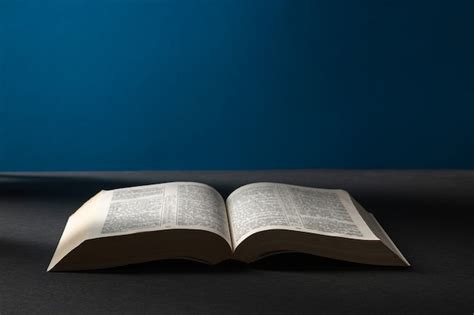 Biblia abierta en una oscuridad en un haz de luz. | Foto Premium