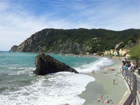 people are standing on the beach near the water