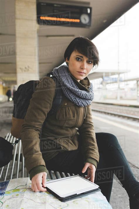 Portrait of female backpacker with map and digital tablet on railway platform - Stock Photo ...