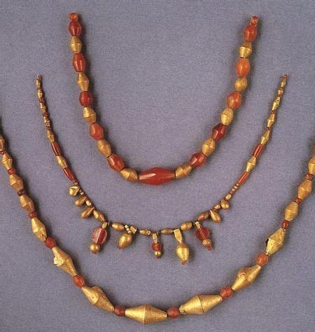 Gold and carnelian beads. The gold beads of this type were made of gold foil wrapped around a ...