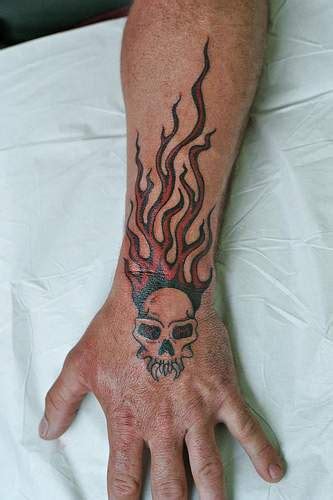 Demon skull on fire arm tattoo - Tattooimages.biz