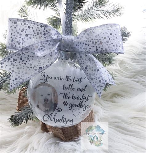 a glass ornament with a dog's photo on it and a bow