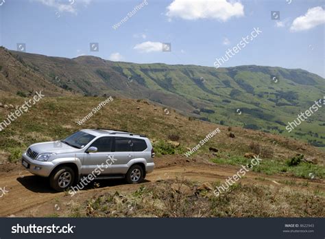 A 4x4 Vehicle Driving On A Dirt Road Leading Up The Drakensberg Mountain Range, Kzn, South ...