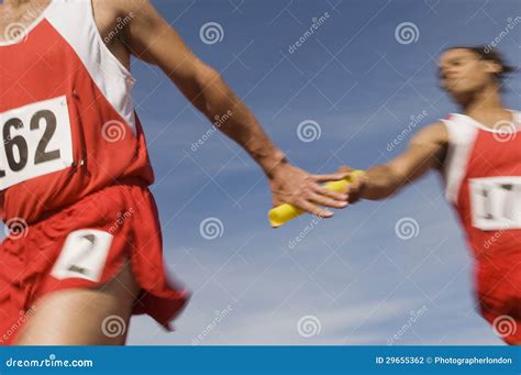 Athletes Passing Baton In Relay Race Stock Photo - Image of competition ...